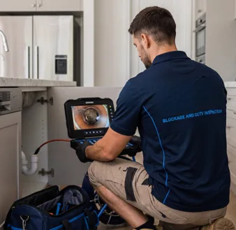 Plumber clearing a blocked toilet in a Bella Vista bathroom